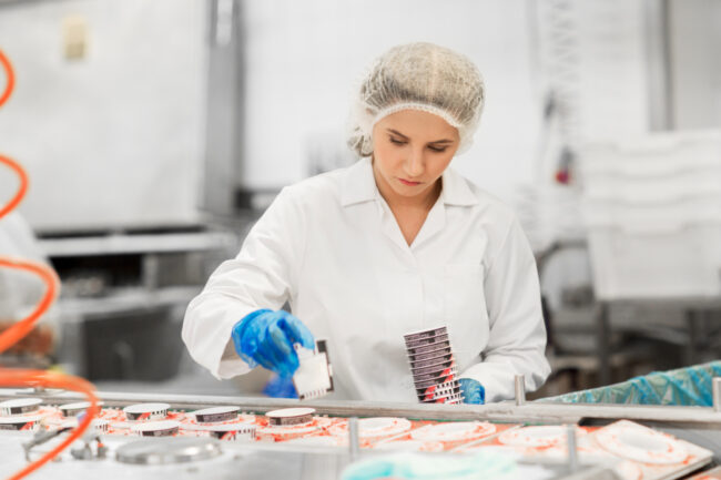 Woman working on ice cream manufacturing line