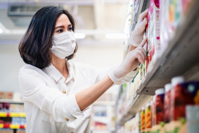 woman grocery shopping with a face mask on