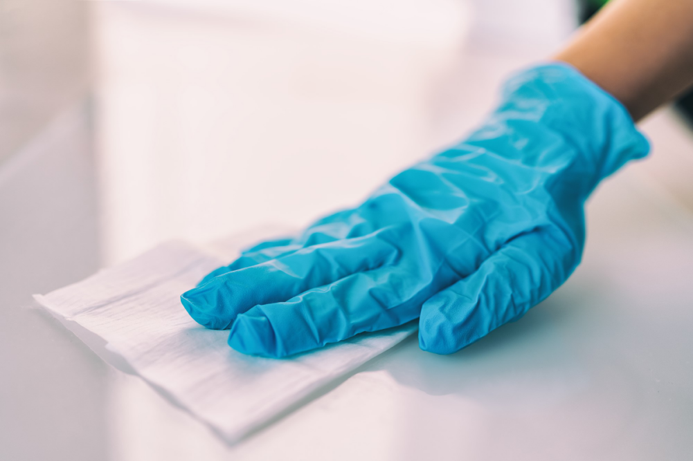 Cleaning staff disinfecting work surface