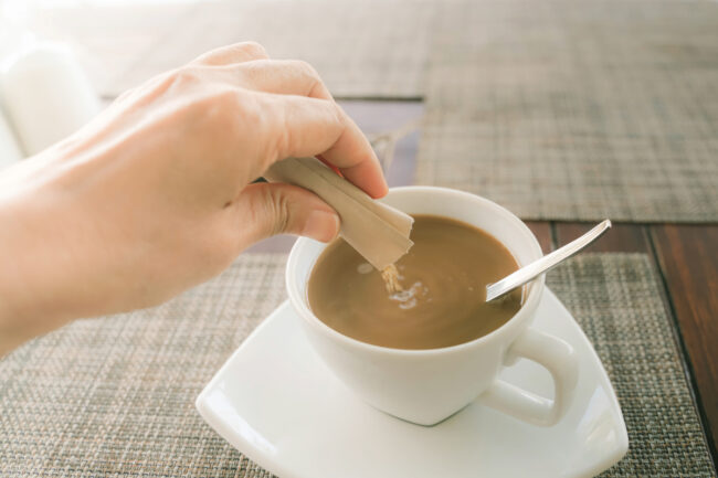 hand pouring sugar